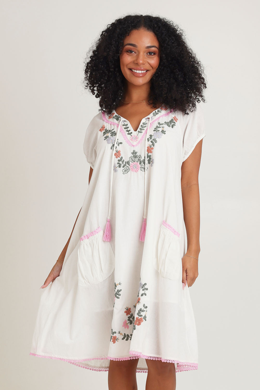 Model Ziara wearing size S of the Sao Paulo Cotton Dress in colour Jewel (White), from the front, cropped image