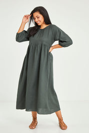 Model Terri-Leigh wearing size 14 of the Linen Gathered Waist Dress in colour Green (Green), from the front, showing the whole outfit