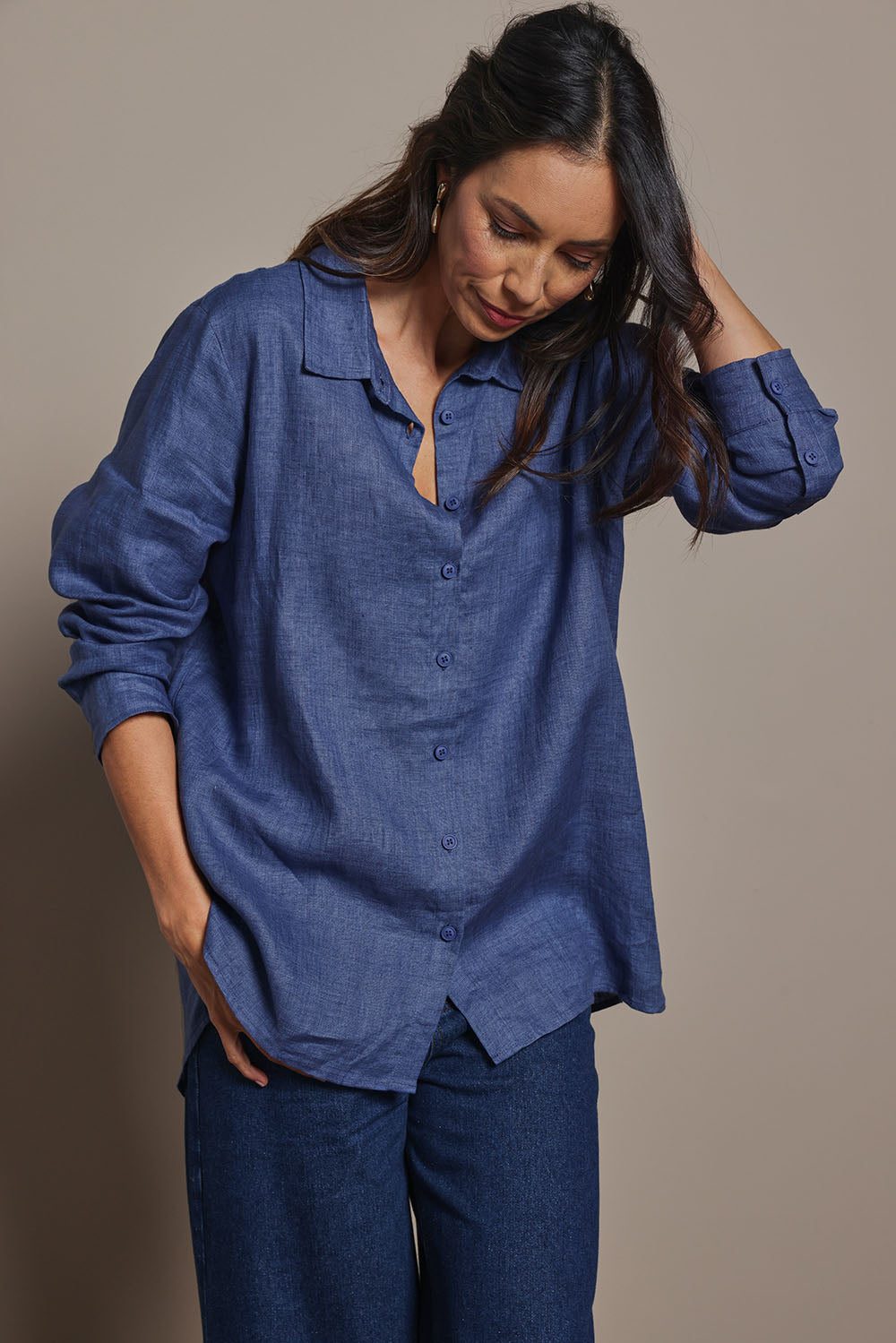 Model Amanda wearing size 10 of the Linen Oversized Boyfriend Shirt in colour Denim (Blue), from the front, cropped image