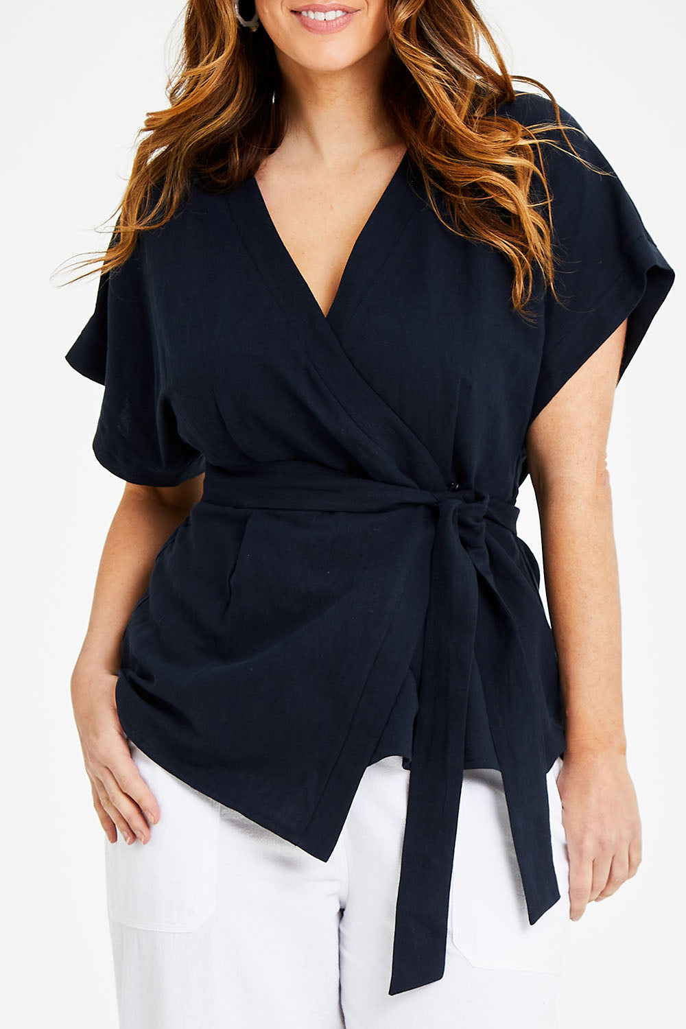 Model Laura wearing size 14 of the Linen Cotton Wrap Blouse in colour Navy (Blue), from the front, cropped image
