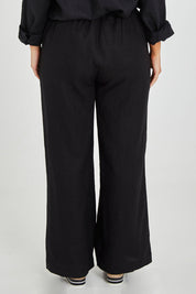 Model Monique wearing size 14 of the Linen Wide Leg Pant in colour Black (Black), from the back