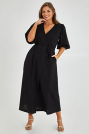 Model Monique wearing size 14 of the Linen Cotton Blend Wrap Dress in colour Black (Black), from the front, showing the whole outfit
