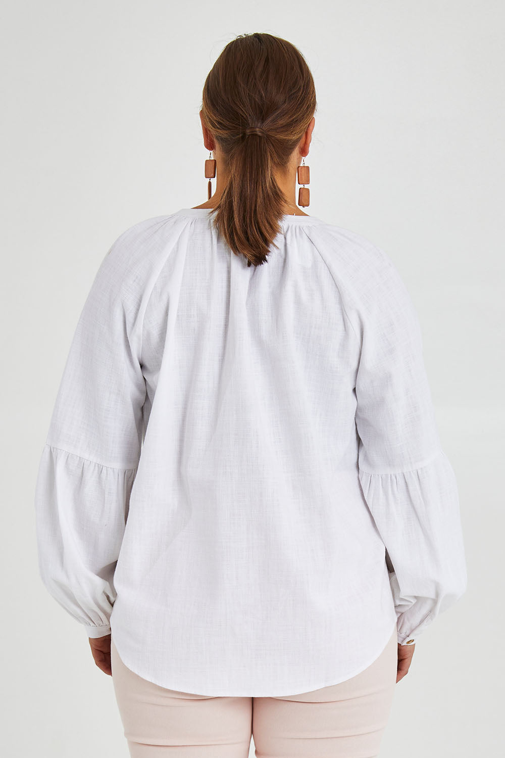 Model Monique wearing size 14 of the Relaxed Linen Blouse in colour White (White), from the back