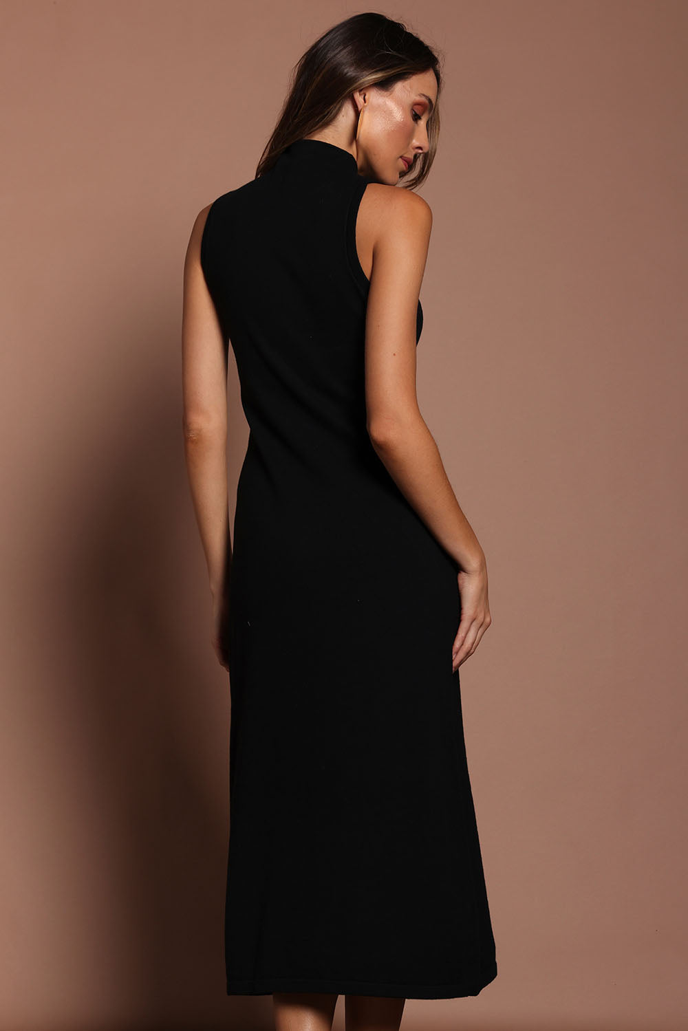 Model Madeline wearing size S of the Cotton Cashmere Sleeveless Layering Dress in colour Black (Black), from the back