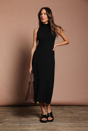 Model Madeline wearing size S of the Cotton Cashmere Sleeveless Layering Dress in colour Black (Black), from the front, showing the whole outfit