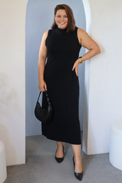 Model Stacey wearing size L of the Cotton Cashmere Sleeveless Layering Dress in colour Black (Black), from the front, showing the whole outfit