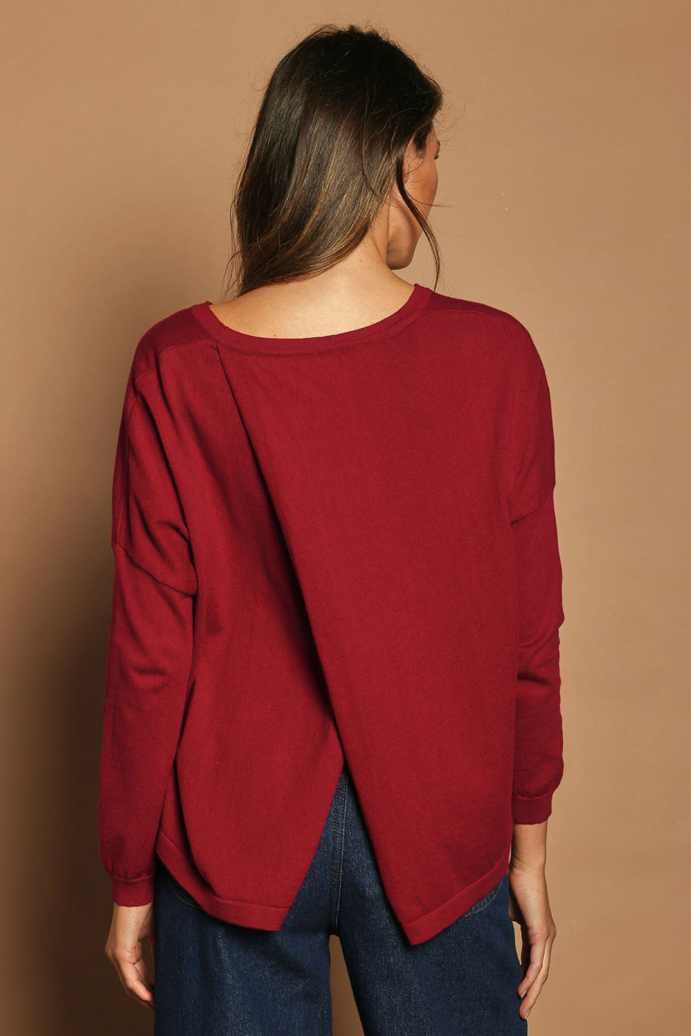 Model Madeline wearing size S of the Cotton Cashmere Cross Back Sweater in colour Redrust (Red), from the back