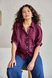 Model Tahneei wearing size 10 of the Linen Pleated Sleeve Shirt – Plum in colour Plum, in a cropped view