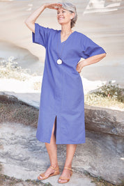 Model Charlotte wearing size 10 of the Natural Throw Dress in colour Fleet (Blue), from the front, showing the whole outfit