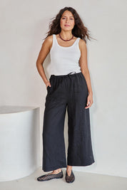 Model Tahneei wearing size 10 of the Linen Cropped Drawstring Pant – Black in colour Black, from the front