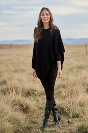 Model Amanda wearing size S of the Cotton Cashmere Wool Poncho in colour Black (Black), from the front, showing the whole outfit