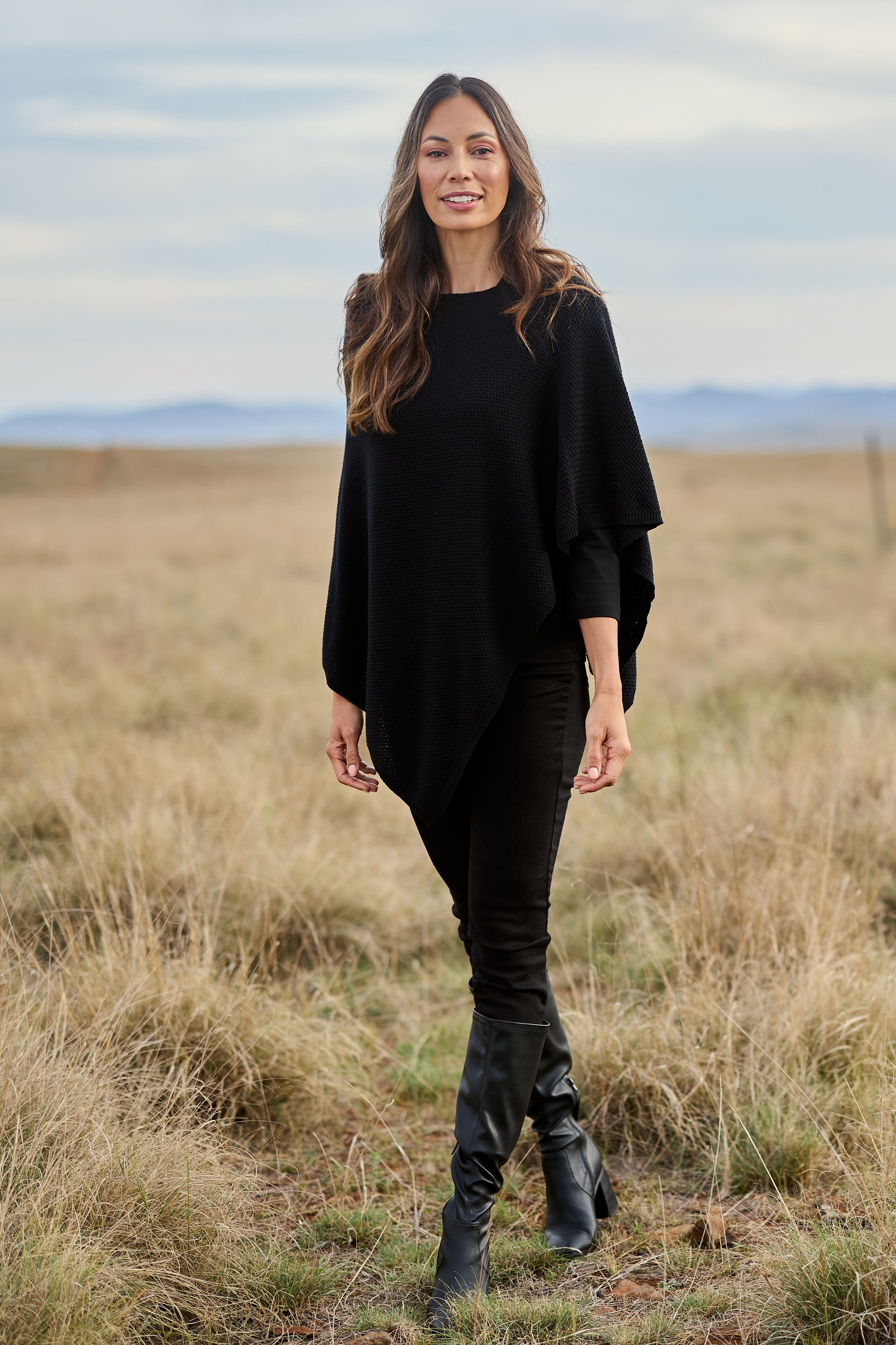 Model Amanda wearing size S of the Cotton Cashmere Wool Poncho in colour Black (Black), from the front, showing the whole outfit