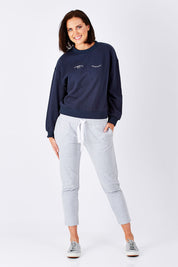 Model Perrie wearing size 10 of the Roosevelt Trackpant in colour GreyMarle (Grey), from the front, showing the whole outfit