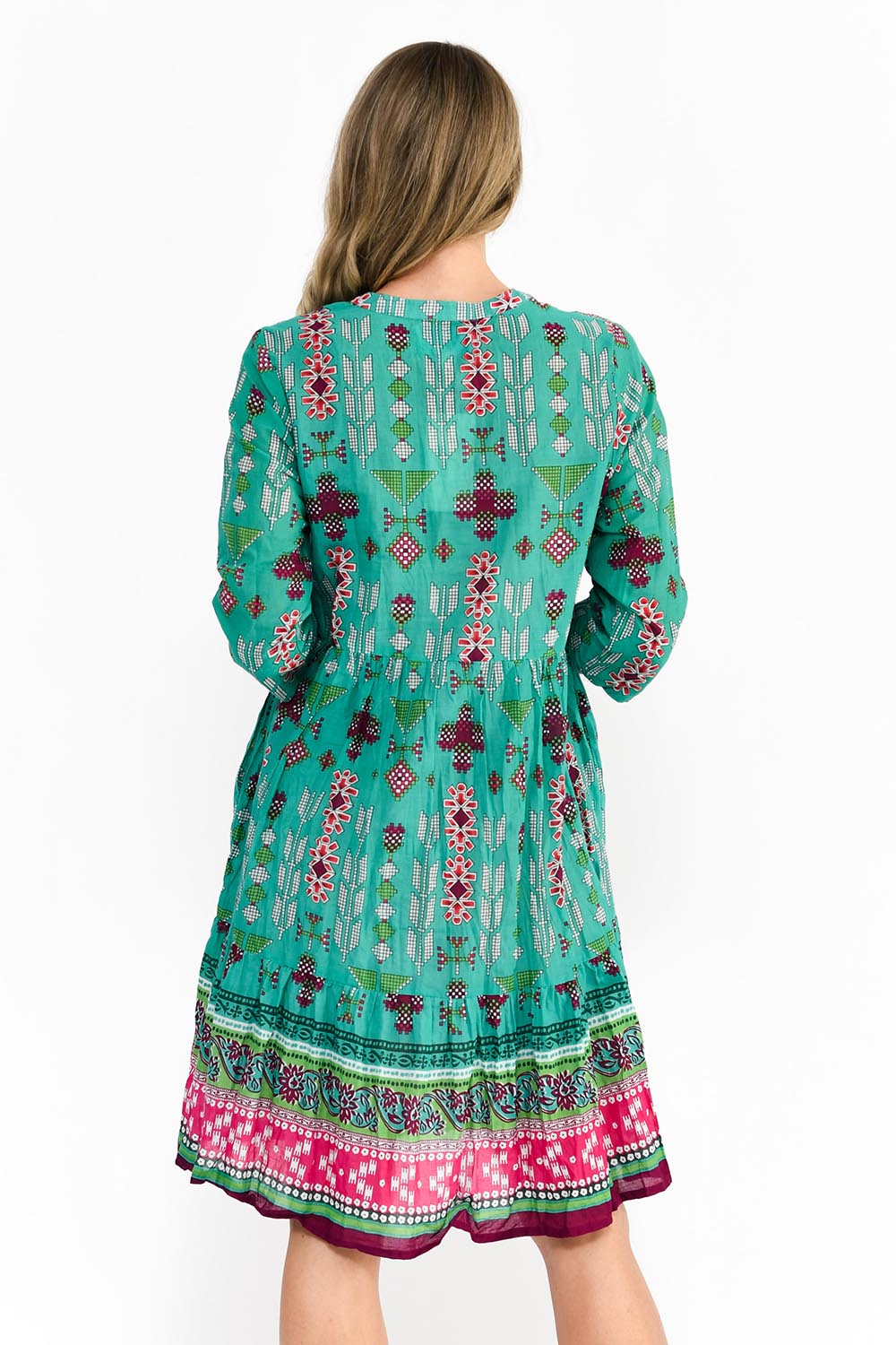 A model wearing the Border Cotton Dress in colour Aztec1 (Green), from the back