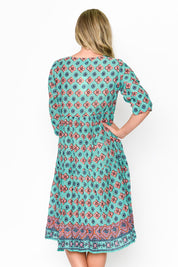 A model wearing the Rebecca Cotton Tie Neck Dress in colour Diamond1 (Blue), from the back