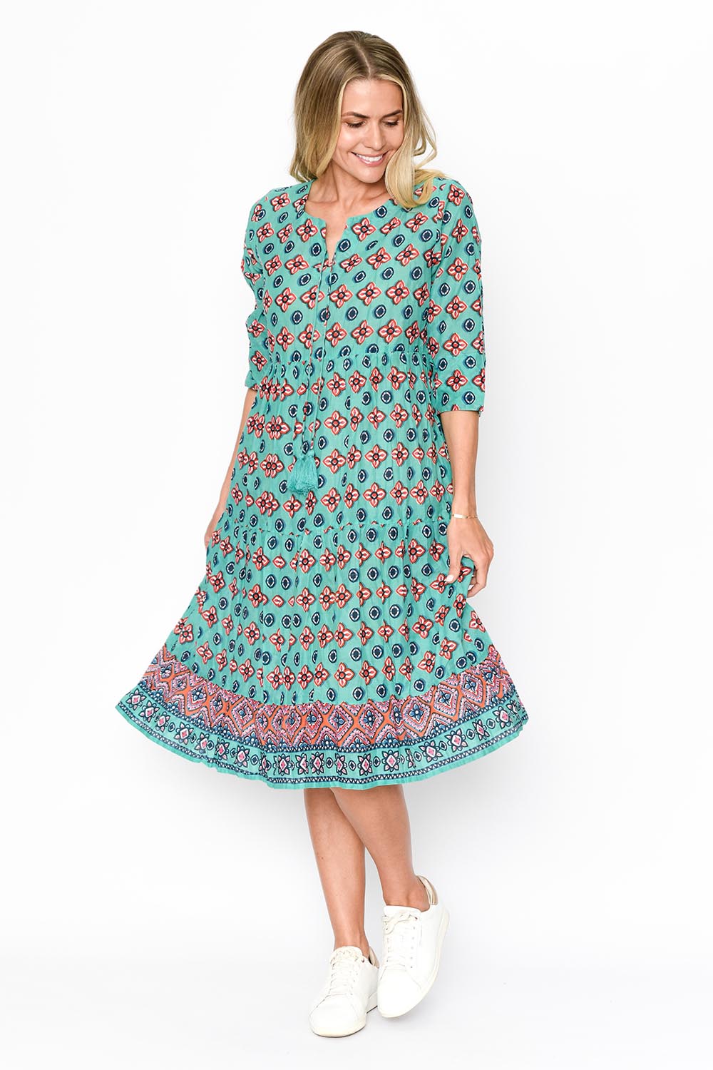 A model wearing the Rebecca Cotton Tie Neck Dress in colour Diamond1 (Blue), from the front, showing the whole outfit