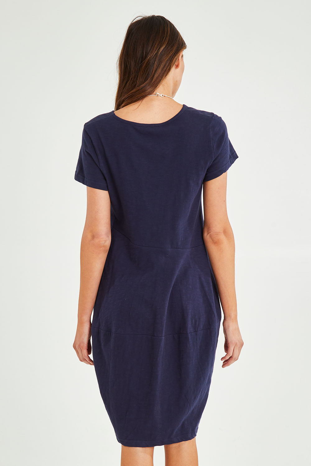 Model Madeline wearing size 10 of the Essentials Organic Cotton Bubble Dress in colour Navy (Blue), from the back