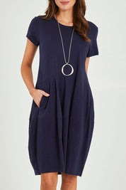 Model Madeline wearing size 10 of the Essentials Organic Cotton Bubble Dress in colour Navy (Blue), from the front, cropped image