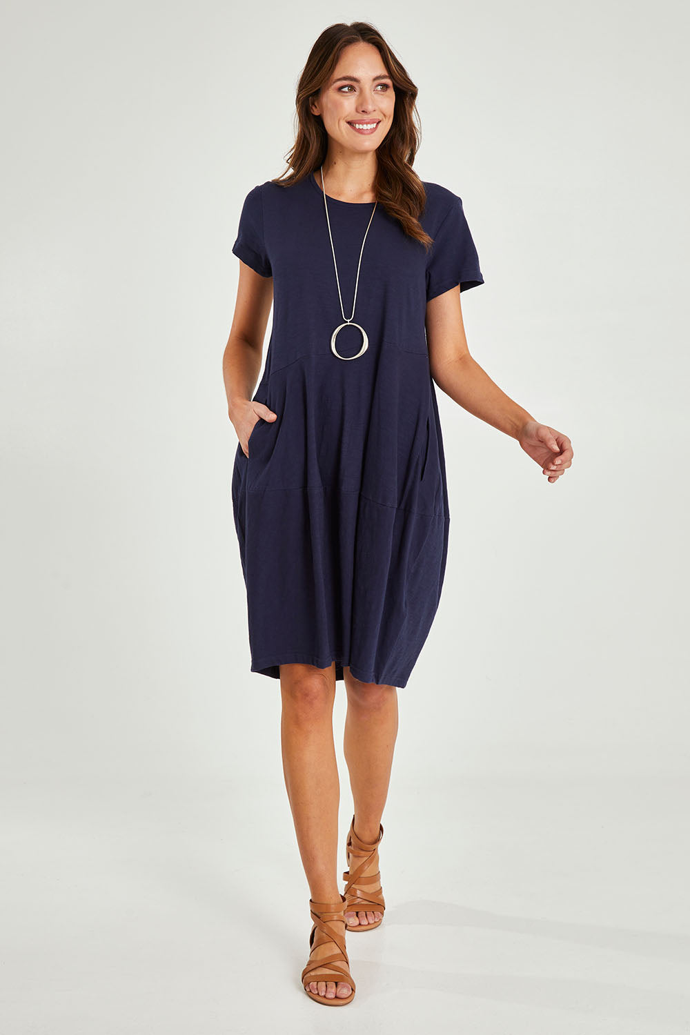 Model Madeline wearing size 10 of the Essentials Organic Cotton Bubble Dress in colour Navy (Blue), from the front, showing the whole outfit