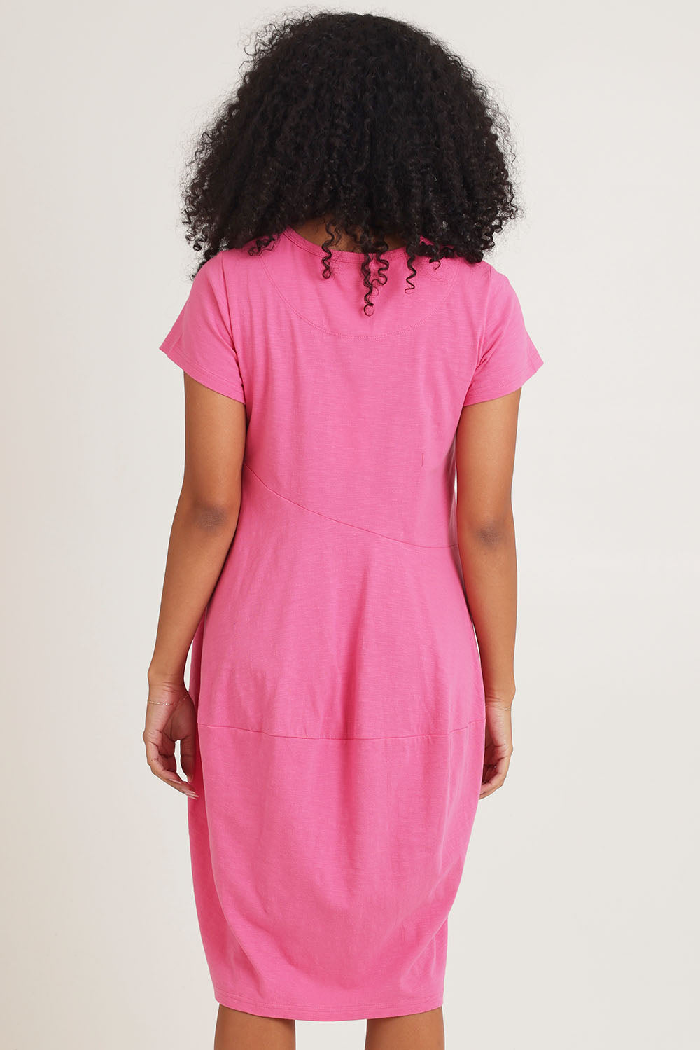 Model Ziara wearing size 10 of the Essentials Organic Cotton Bubble Dress in colour Pink (Pink), from the back