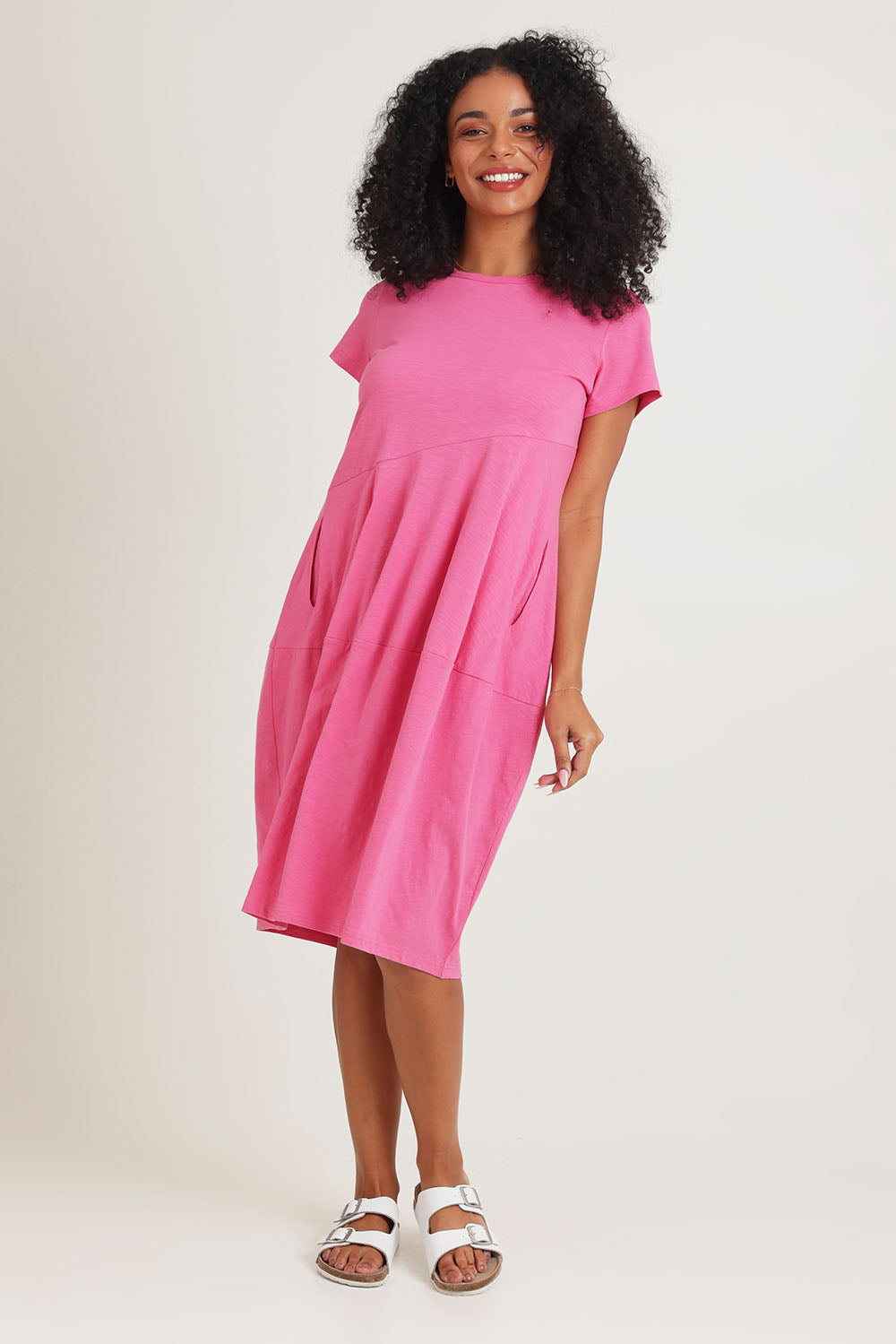 Model Ziara wearing size 10 of the Essentials Organic Cotton Bubble Dress in colour Pink (Pink), from the front, showing the whole outfit