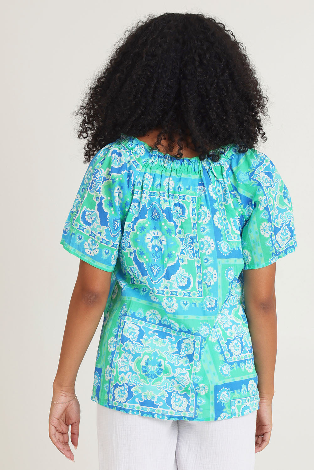 Model Ziara wearing size 10 of the Short Sleeve Cotton Top in colour Aqua (Blue), from the back