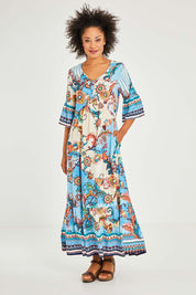 Model Olivia wearing size 10 of the Moster Peak Maxi Dress in colour Print (Blue), from the front, showing the whole outfit