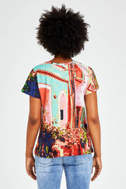 Model Olivia wearing size 10 of the Ville Cora Organic Cotton Tee in colour Villecora (Pink), from the back