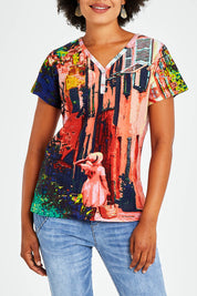 Model Olivia wearing size 10 of the Ville Cora Organic Cotton Tee in colour Villecora (Pink), from the front, cropped image