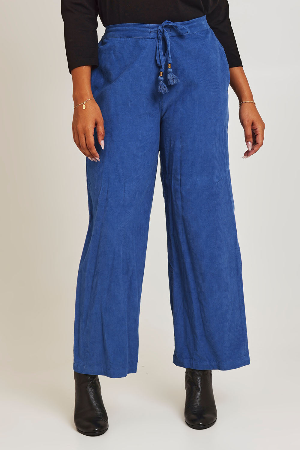 Model Ziara wearing size 10 of the Corduroy Flared Trouser in colour Blue (Blue), from the front, cropped image