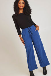Model Ziara wearing size 10 of the Corduroy Flared Trouser in colour Blue (Blue), from the front, showing the whole outfit