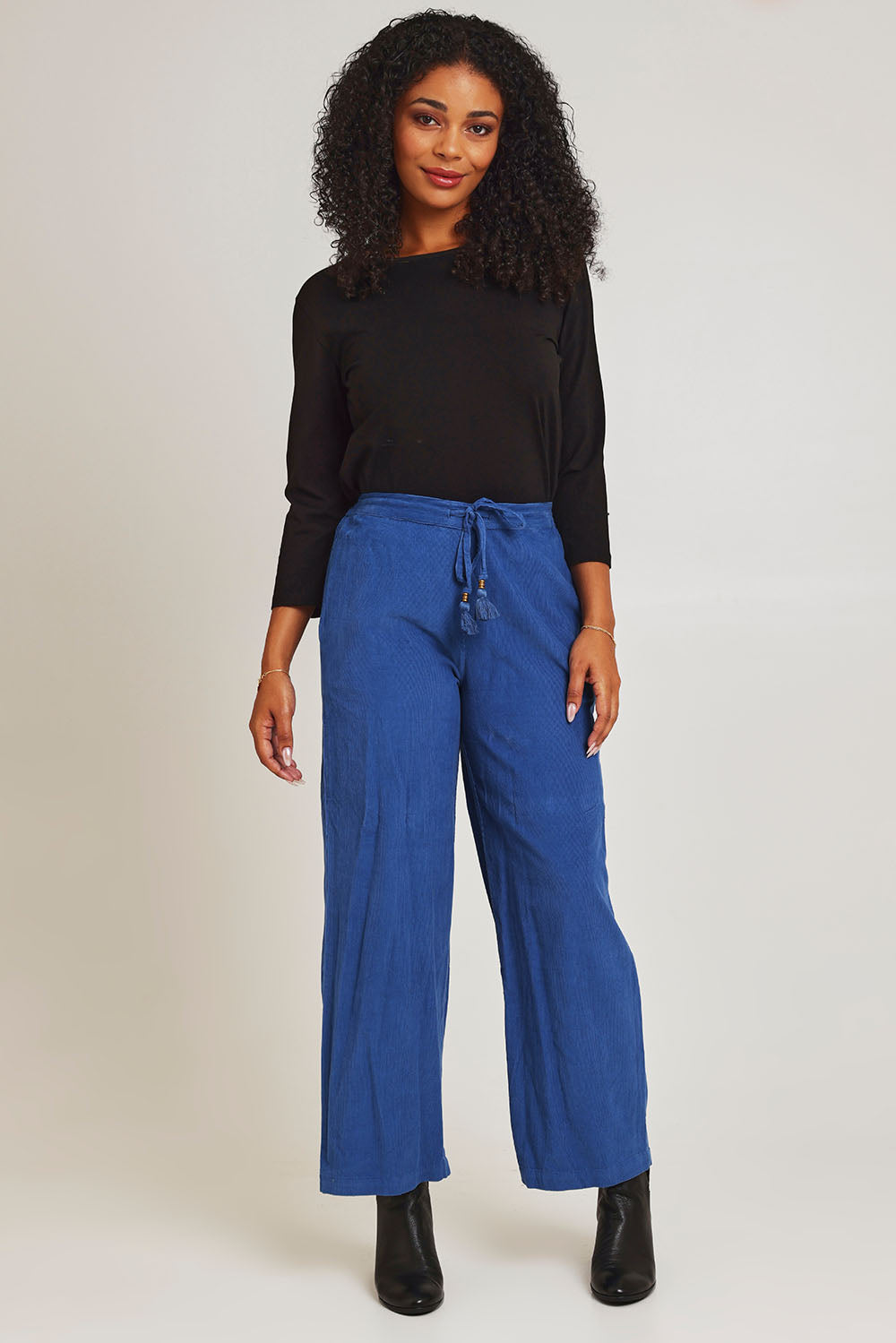 Model Ziara wearing size 10 of the Corduroy Flared Trouser in colour Blue (Blue), from the front, showing the whole outfit