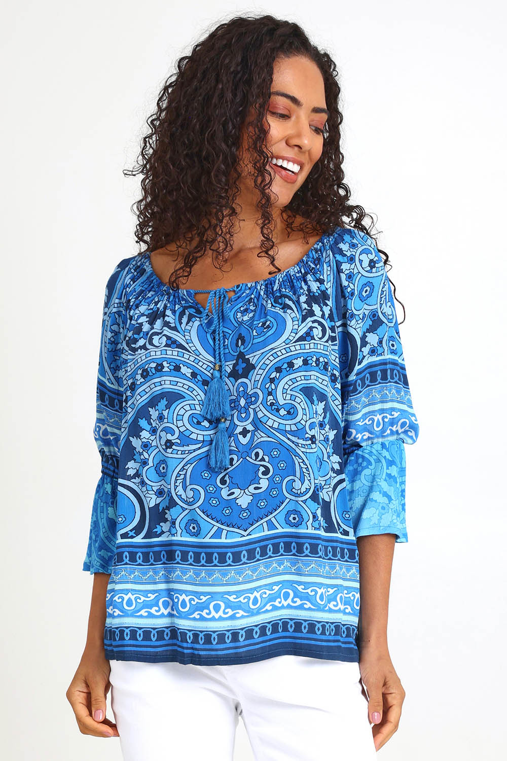 Model Pamelar wearing size 10 of the Boho Tassel Top – Blue in colour Blue, in a cropped view