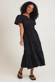Model Ziara wearing size 10 of the Essentials Organic Cotton Poplin Maxi Ruched Waist Dress in colour Black (Black), from the front, showing the whole outfit