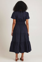 Model Ziara wearing size 10 of the Essentials Organic Cotton Poplin Maxi Ruched Waist Dress in colour Navy (Blue), from the back