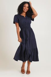 Model Ziara wearing size 10 of the Essentials Organic Cotton Poplin Maxi Ruched Waist Dress in colour Navy (Blue), from the front, showing the whole outfit