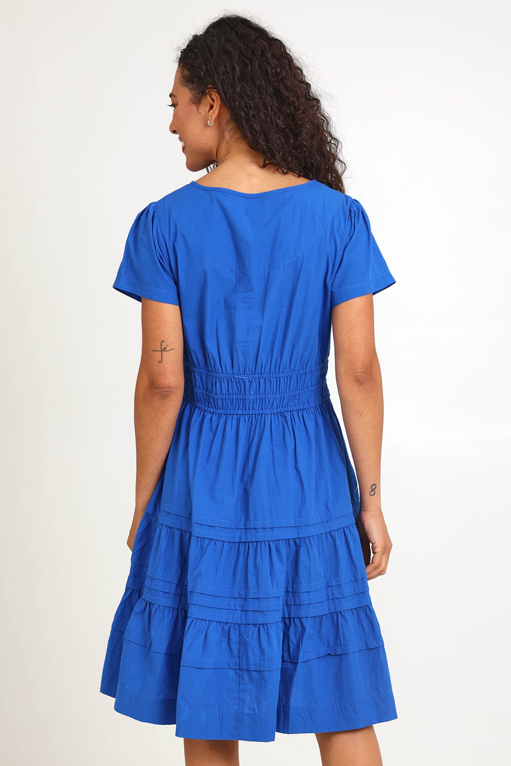 Model Pamelar wearing size 10 of the Essentials Poplin Short Sleeve Cotton Short Dress - Blue in colour Blue, from the back