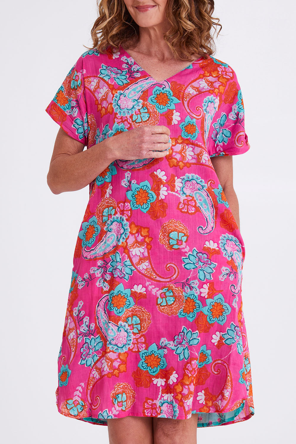 Model Emma wearing size 10 of the Symi Reversible Shift Organic Cotton Dress in colour Aquapink (Pink), from the front, cropped image