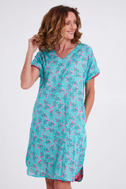 Model Emma wearing size 10 of the Symi Reversible Shift Organic Cotton Dress in colour Aquapink (Pink), from the front, cropped image