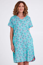 Model Emma wearing size 10 of the Symi Reversible Shift Organic Cotton Dress in colour Aquapink (Pink), from the front, cropped image