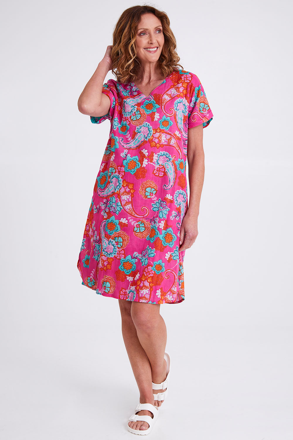 Model Emma wearing size 10 of the Symi Reversible Shift Organic Cotton Dress in colour Aquapink (Pink), from the front, showing the whole outfit