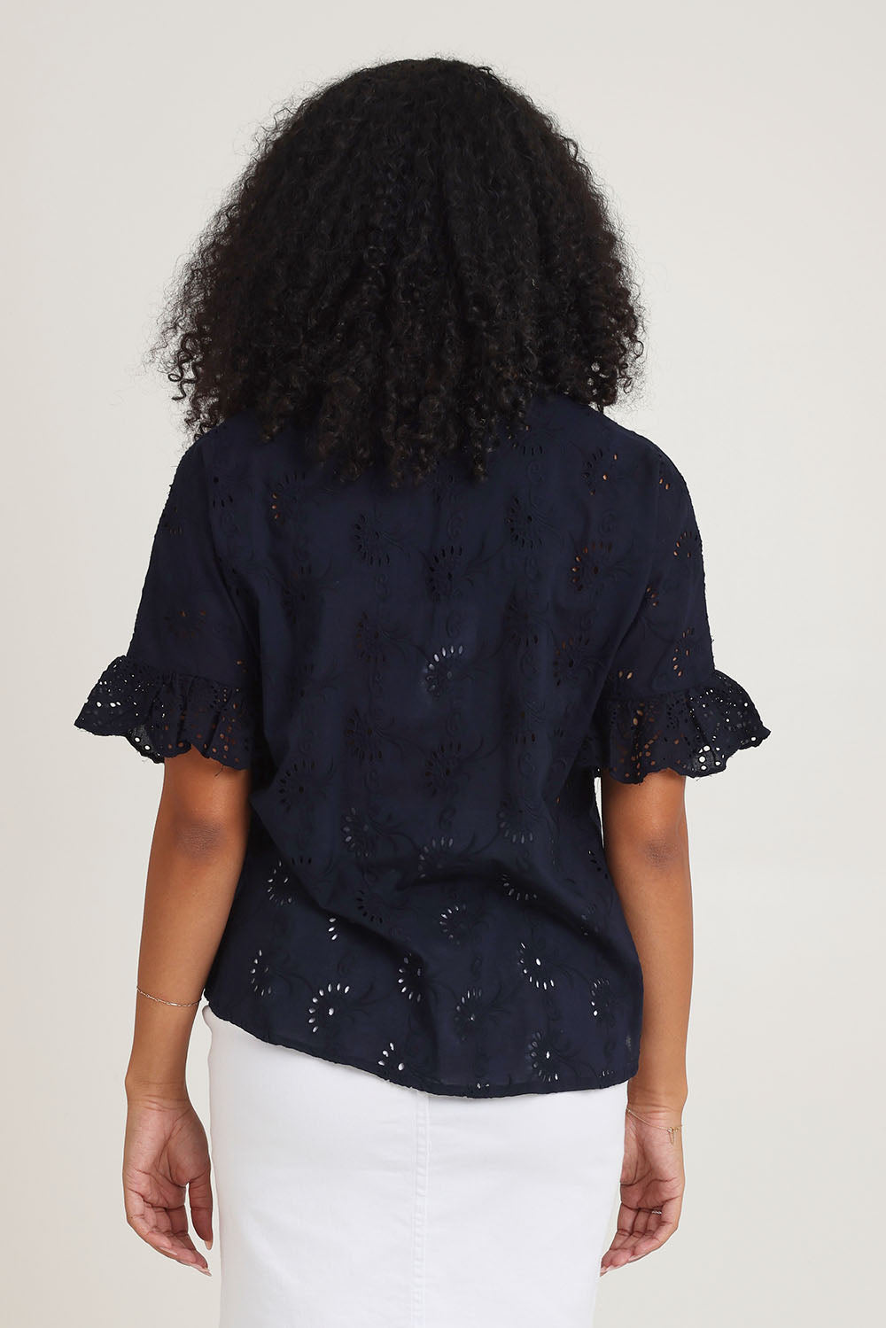 Model Ziara wearing size 10 of the Essentials Broderie Cotton Top in colour Navy (Blue), from the back