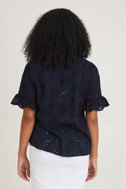 Model Ziara wearing size 10 of the Essentials Broderie Cotton Top in colour Navy (Blue), from the back