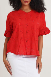 Model Ziara wearing size 10 of the Essentials Broderie Cotton Top in colour Red (Red), from the front, cropped image
