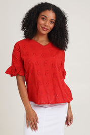 Model Ziara wearing size 10 of the Essentials Broderie Cotton Top in colour Red (Red), from the front, showing the whole outfit