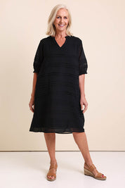 Model Sandys wearing size 10 of the Essentials Pleated Cotton Dress - Black in colour Black, from the front