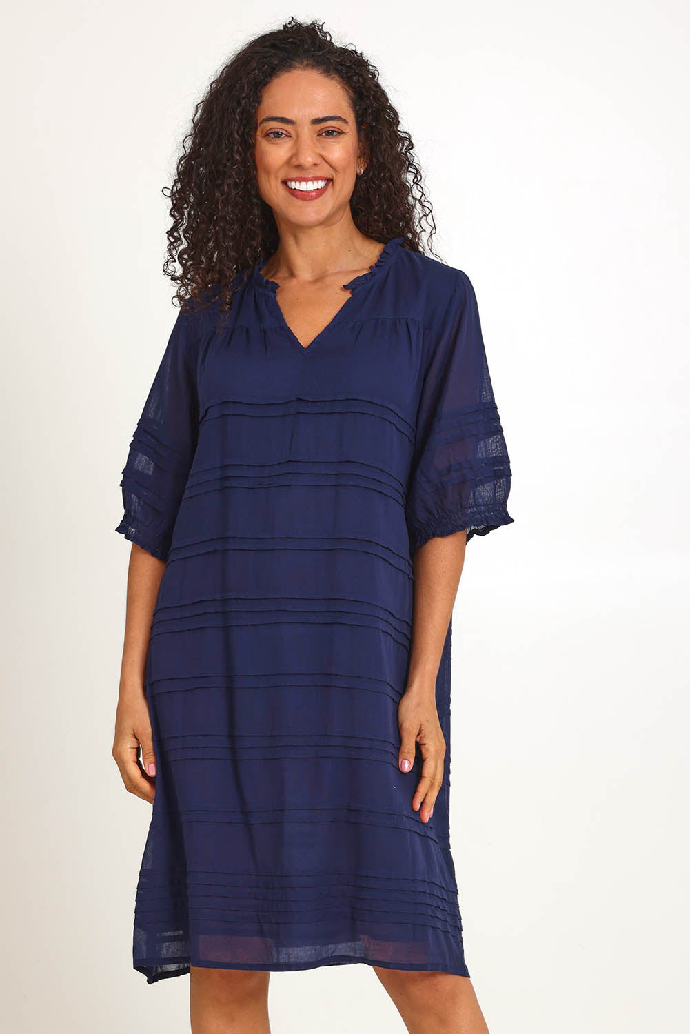Model Pamelar wearing size 10 of the Essentials Pleated Cotton Dress - Navy in colour Navy, in a cropped view