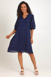 Model Pamelar wearing size 10 of the Essentials Pleated Cotton Dress - Navy in colour Navy, from the front