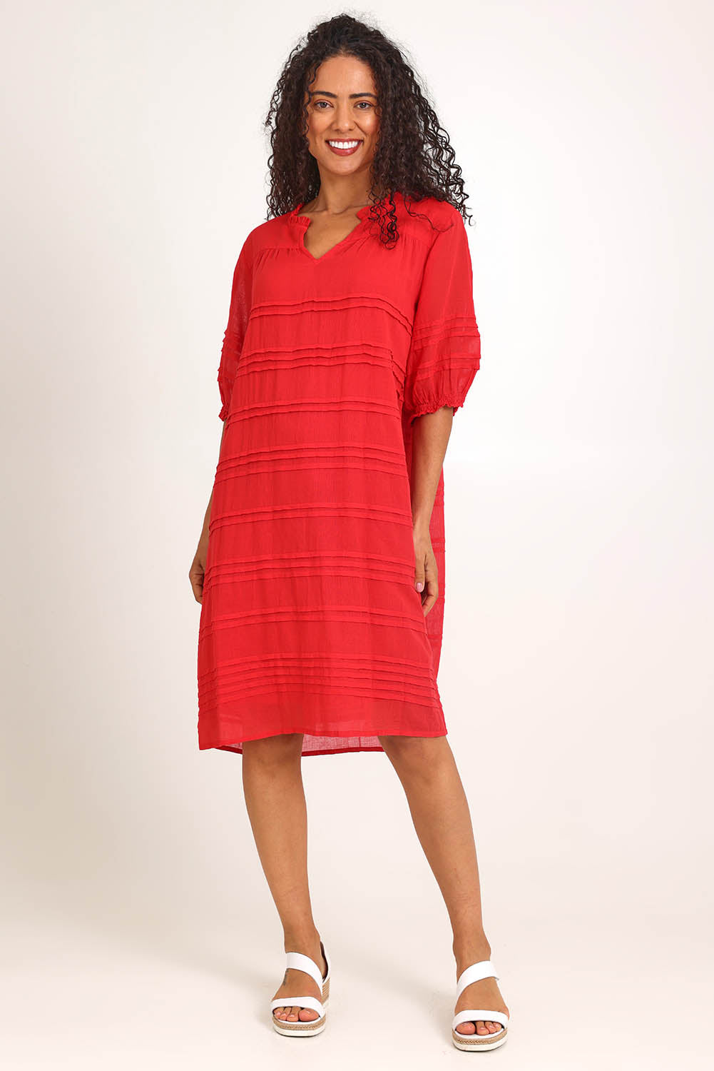 Model Pamelar wearing size 10 of the Essentials Pleated Cotton Dress - Red in colour Red, from the front