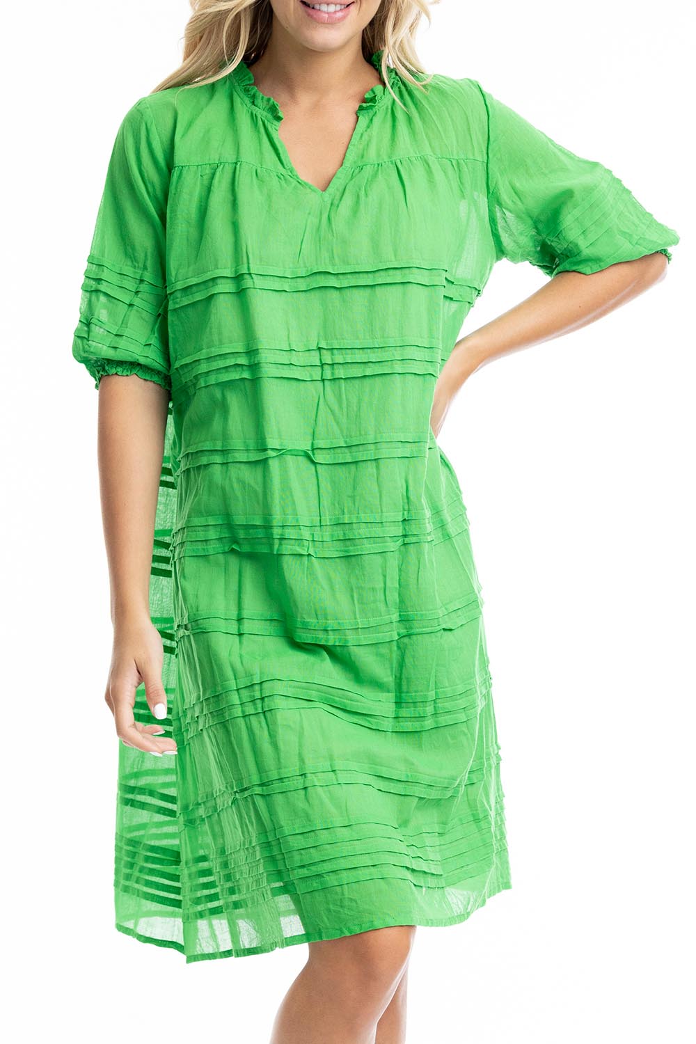 A model wearing the Essentials Organic Cotton Gauze Pleated  Dress in colour Parakeet (Green), from the front, cropped image